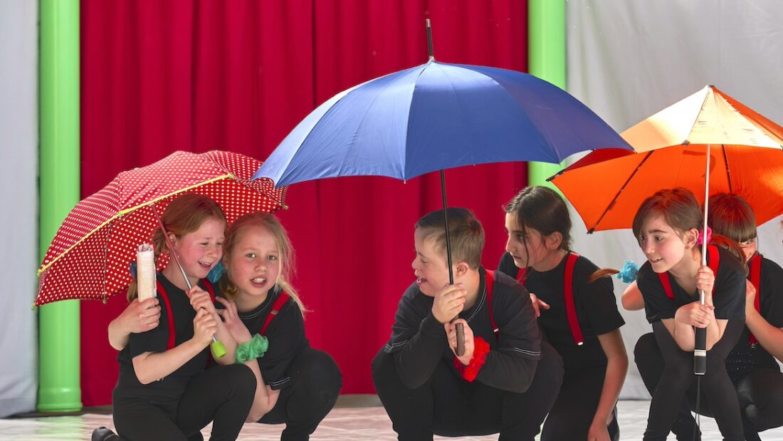 Kinder unter Regenschirmen