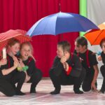 Kinder unter Regenschirmen